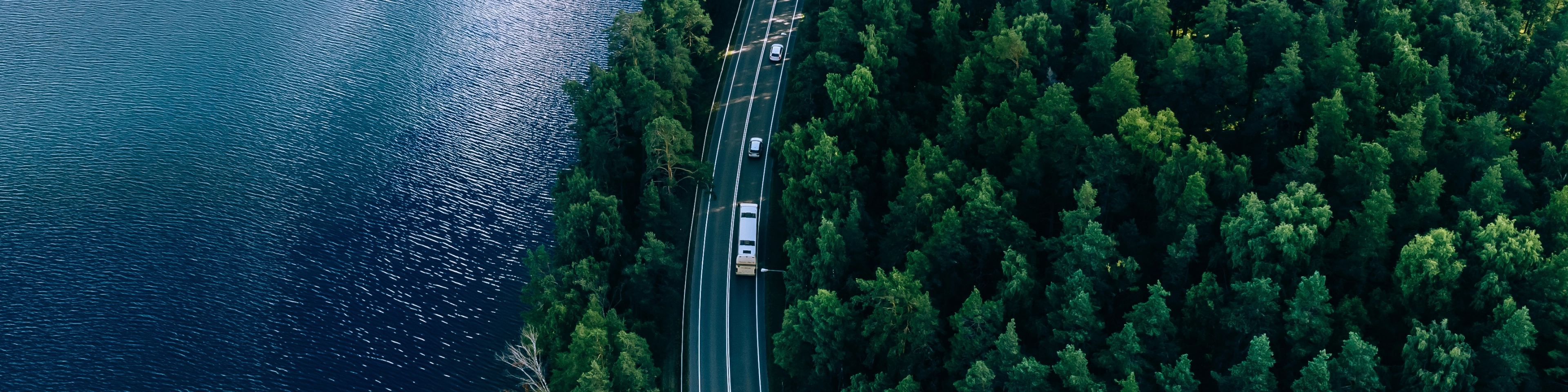 Auta jadące leśną drogą widziane z lotu ptaka