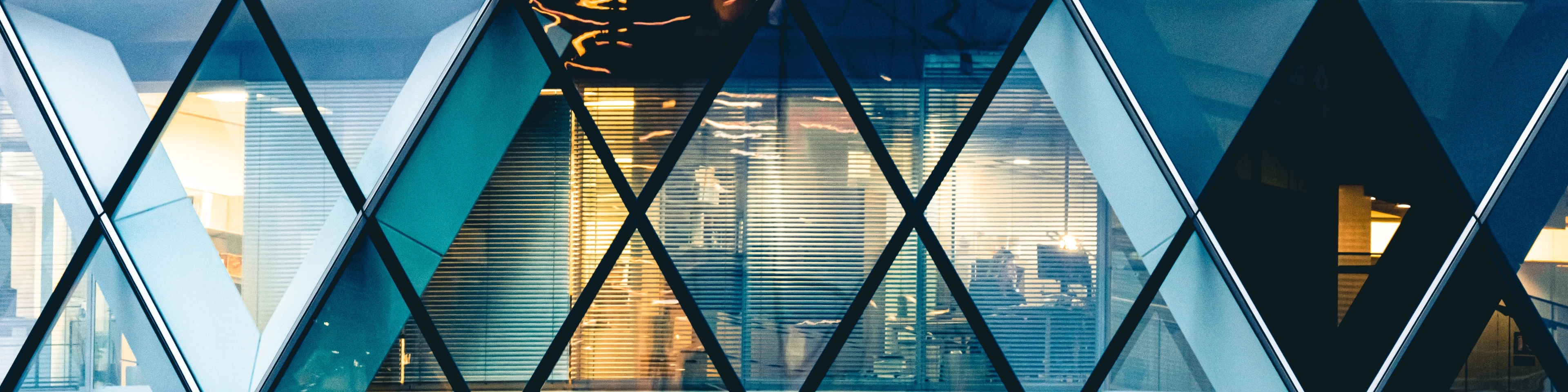 Biura widziane przez mające kształt rombu okna wieżowca