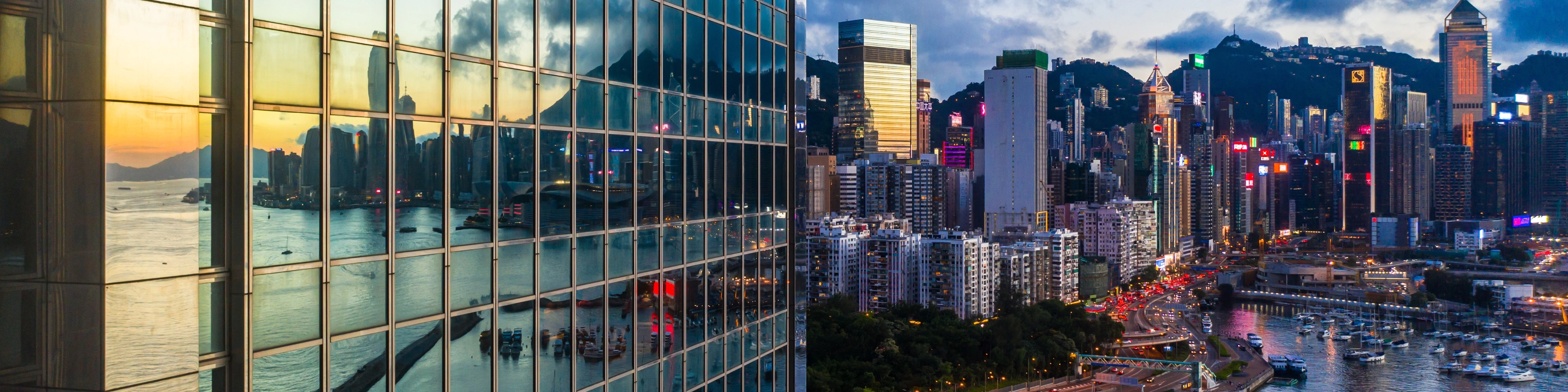 Szklany wieżowiec nad przystanią z jachtami