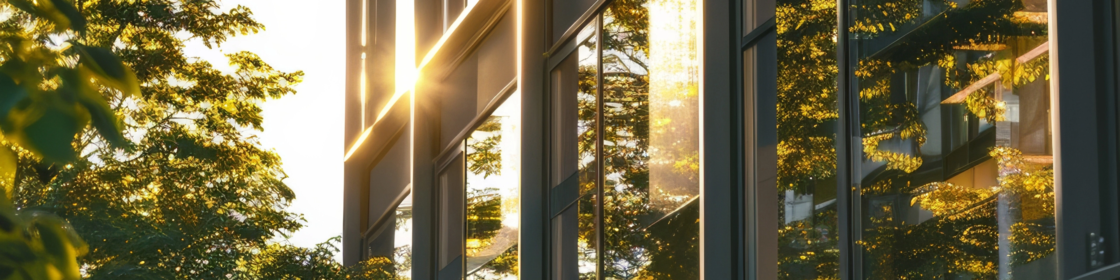 Promienie słoneczne odbijające się w szybie biurowca