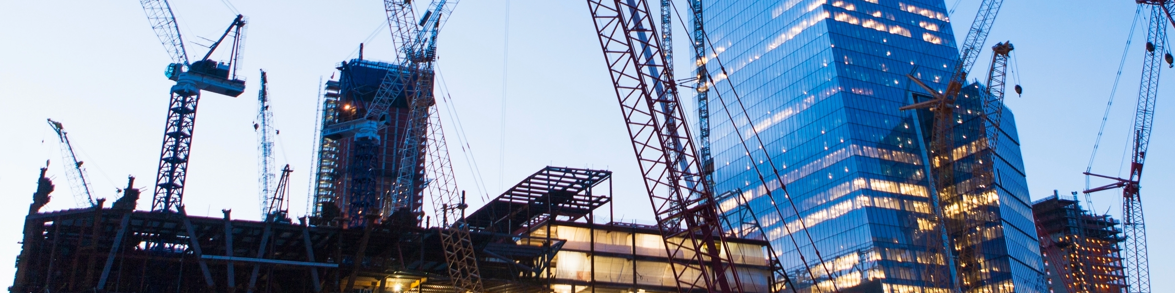 Budynki biurowe otoczone prze żurawie budowlane