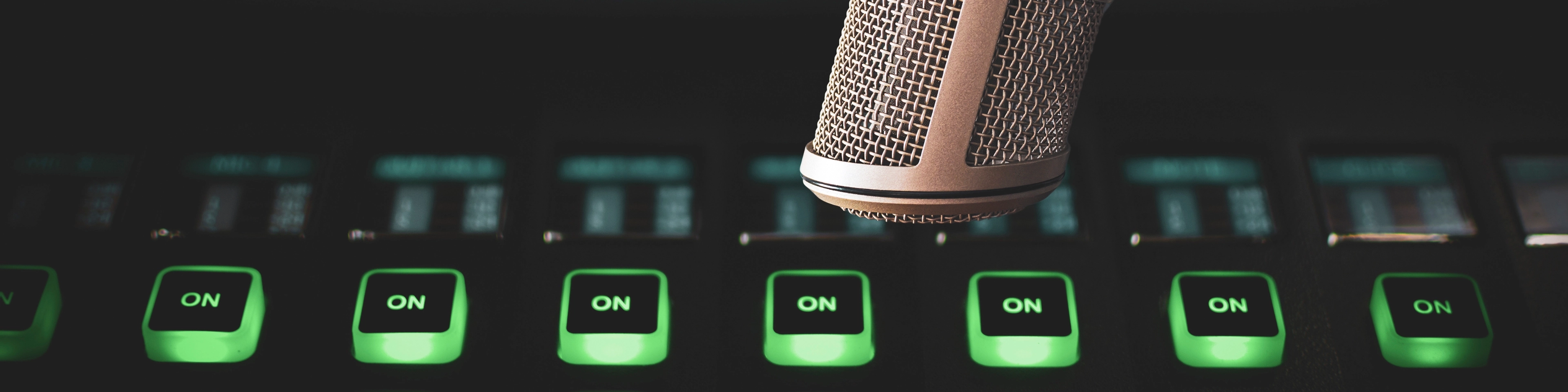 Mikrofon i podświetlone guziki konsoli do obsługi audycji radiowych