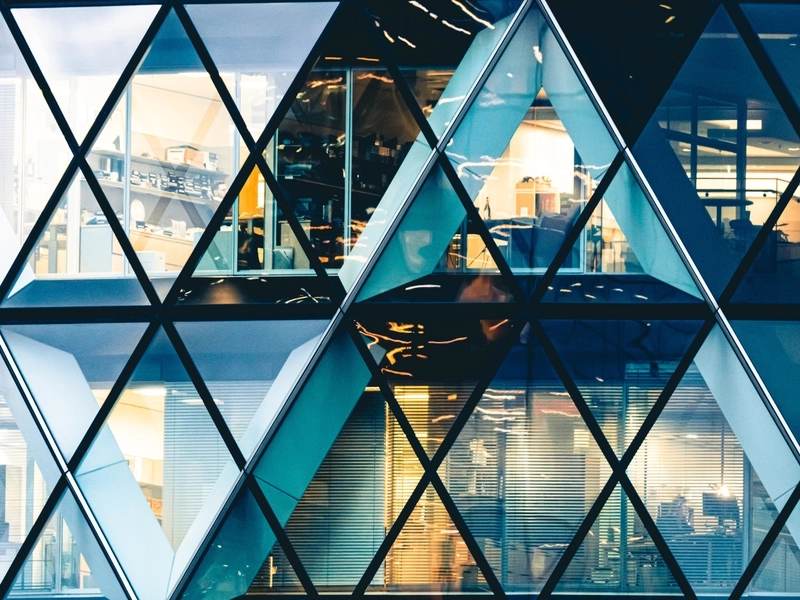 Biura widziane przez mające kształt rombu okna wieżowca