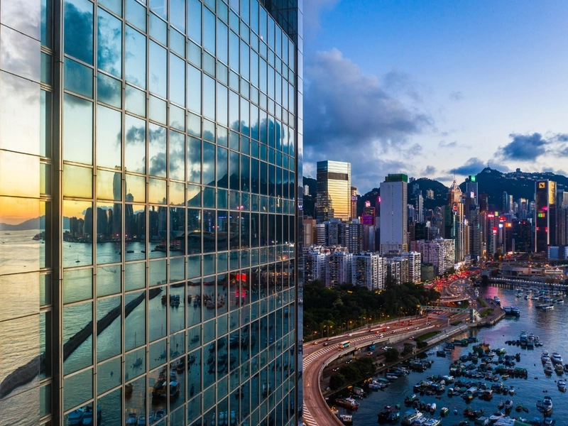 Szklany wieżowiec nad przystanią z jachtami