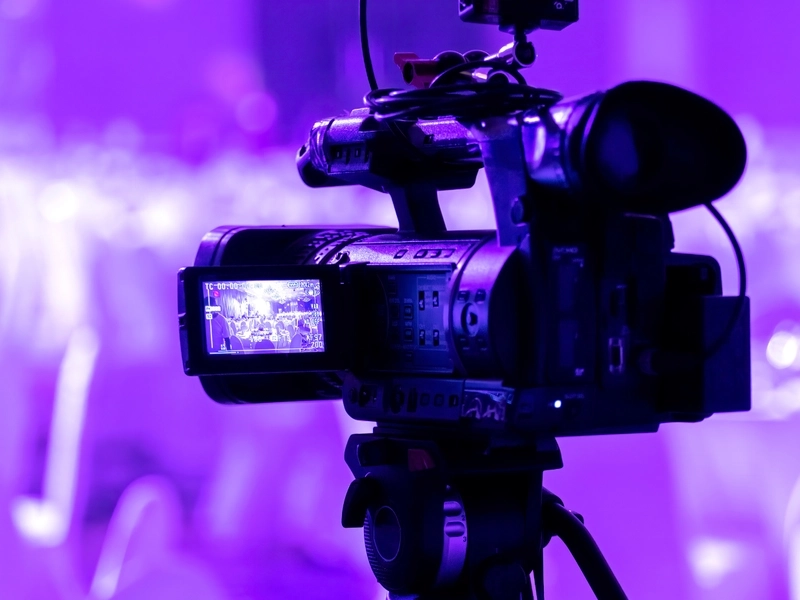 Kamera wideo skierowana w stronę fioletowego tłumu